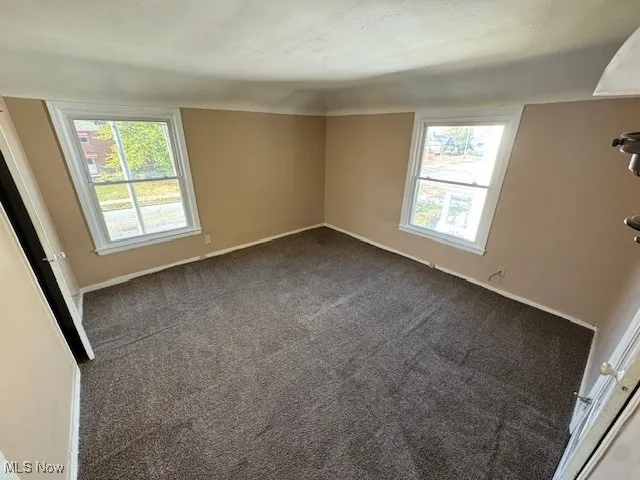 Unfurnished bedroom with carpet flooring and baseboards