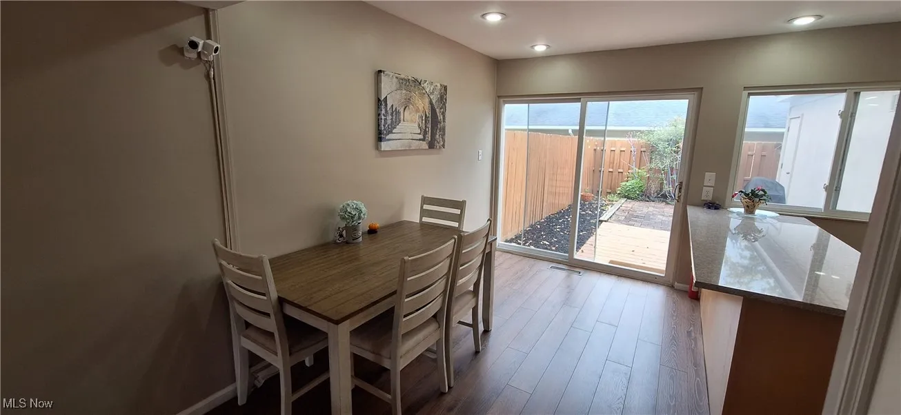 Dining area with dark wood finished floors and recessed lighting