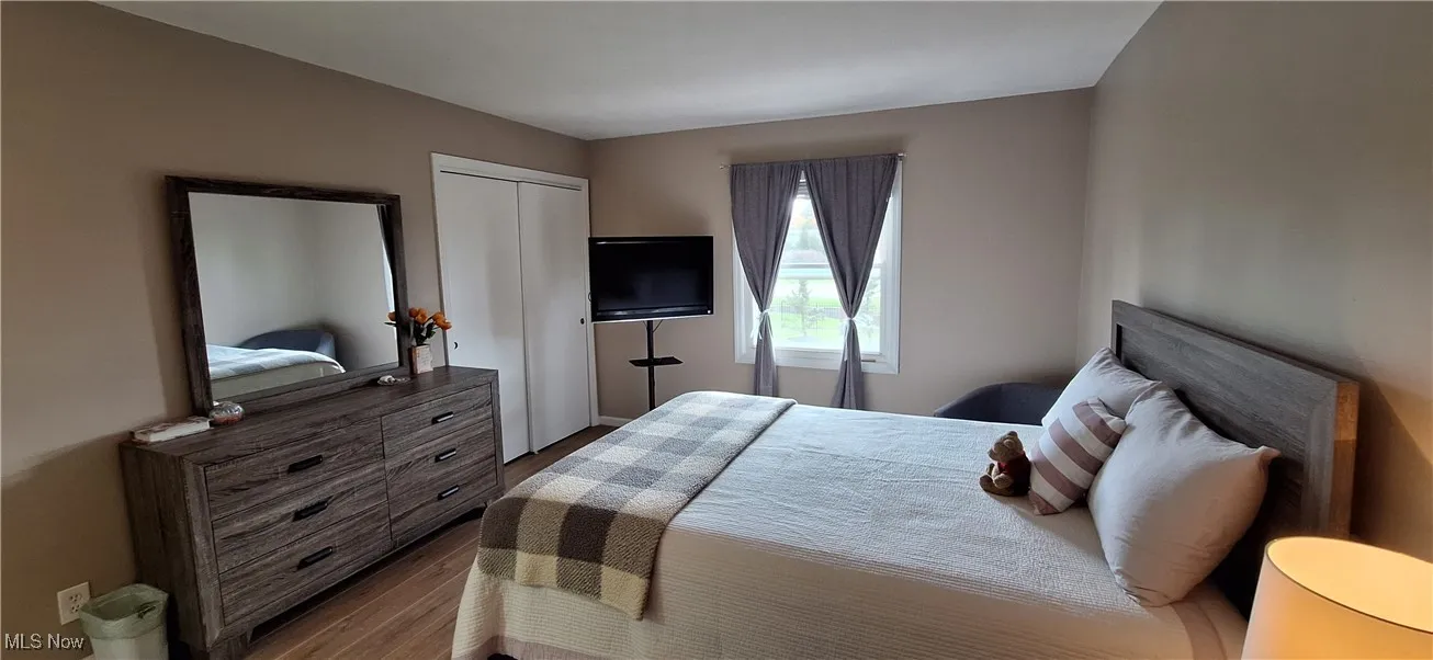 Bedroom featuring wood finished floors and a closet