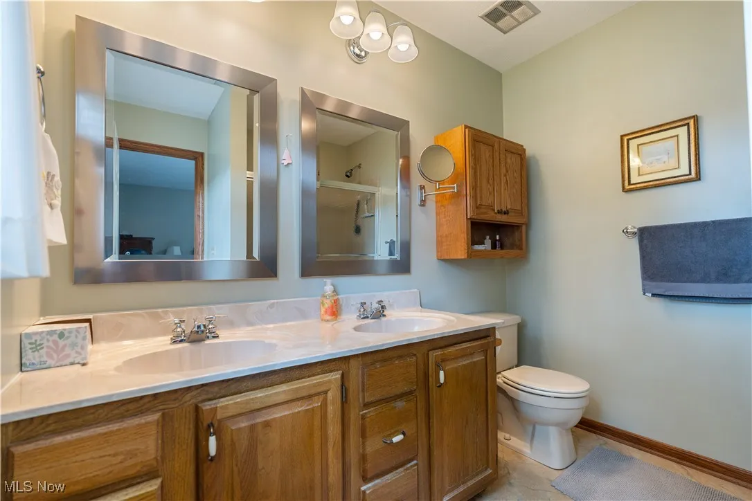 Bathroom featuring a double vanity, and tub/shower combo with sliding doors.