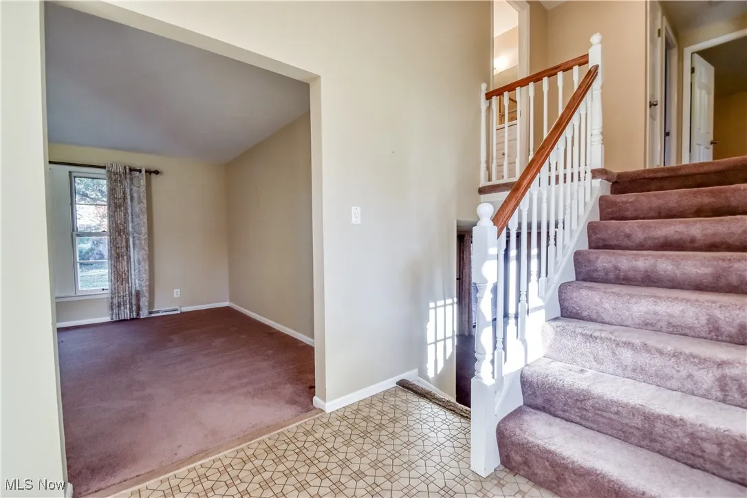 Stairs with carpet and vaulted ceiling