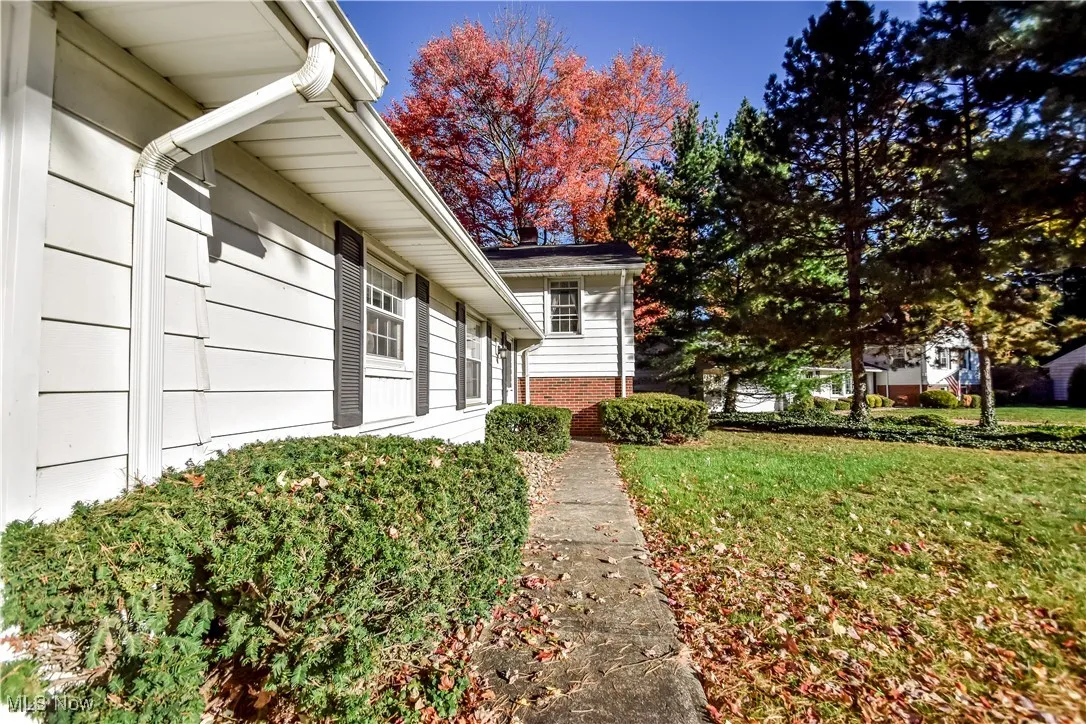 View of side of property featuring a yard and brick siding