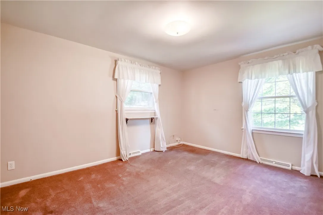 Carpeted empty room with baseboards