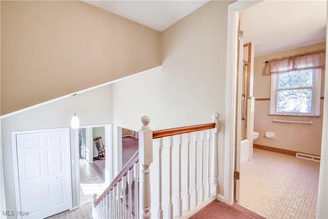Hall with an upstairs landing and tile walls