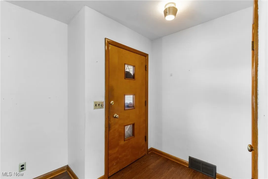 Entryway featuring dark wood-style floors and baseboards