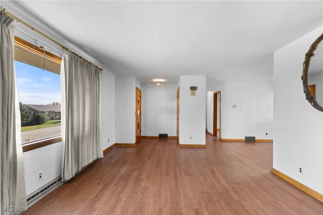 Empty room featuring wood finished floors and baseboards