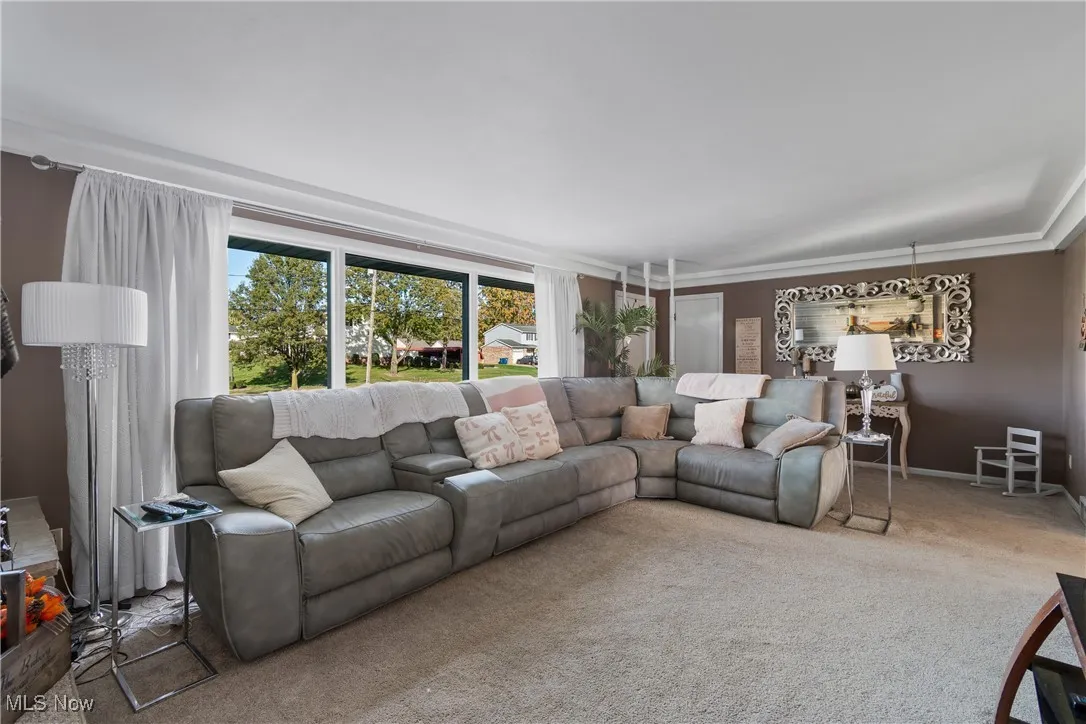 Carpeted living area featuring baseboards