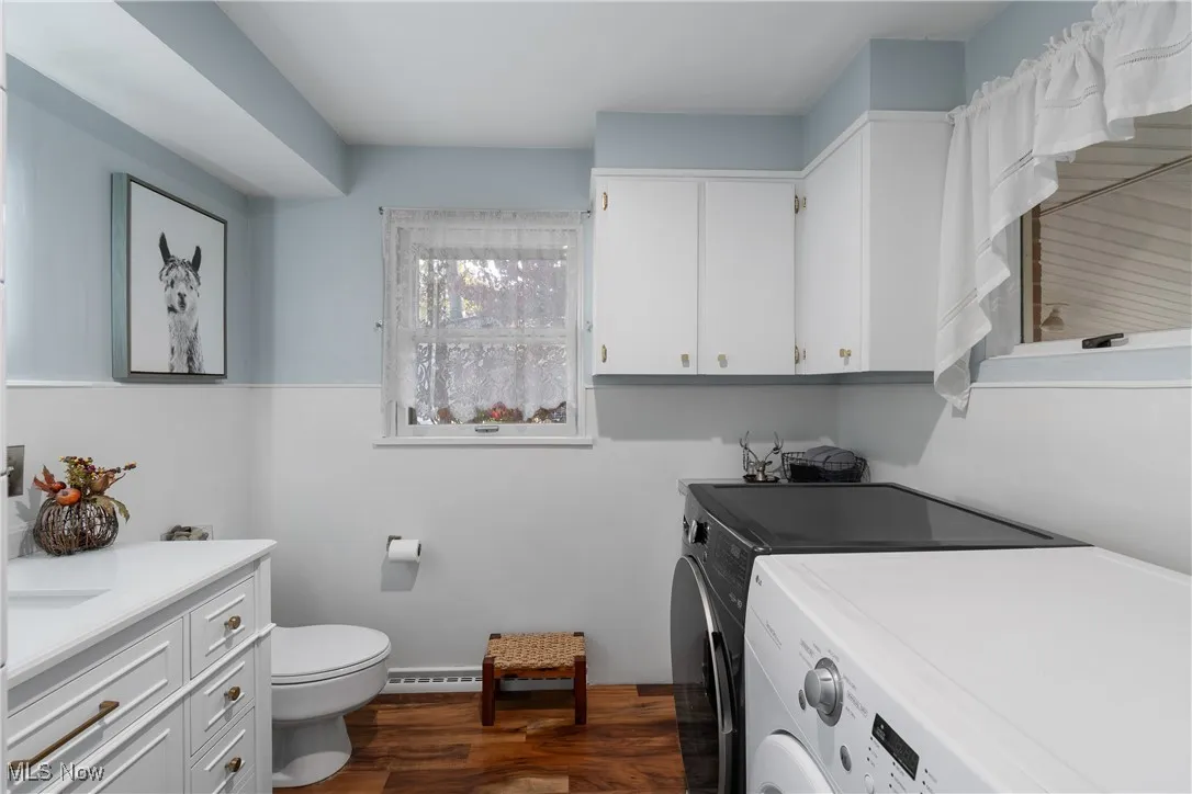 Laundry room with dark wood-style floors and washer and dryer
