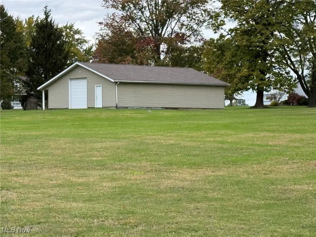 View of green lawn with a detached garage