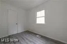 Unfurnished bedroom with dark wood-style floors and baseboards