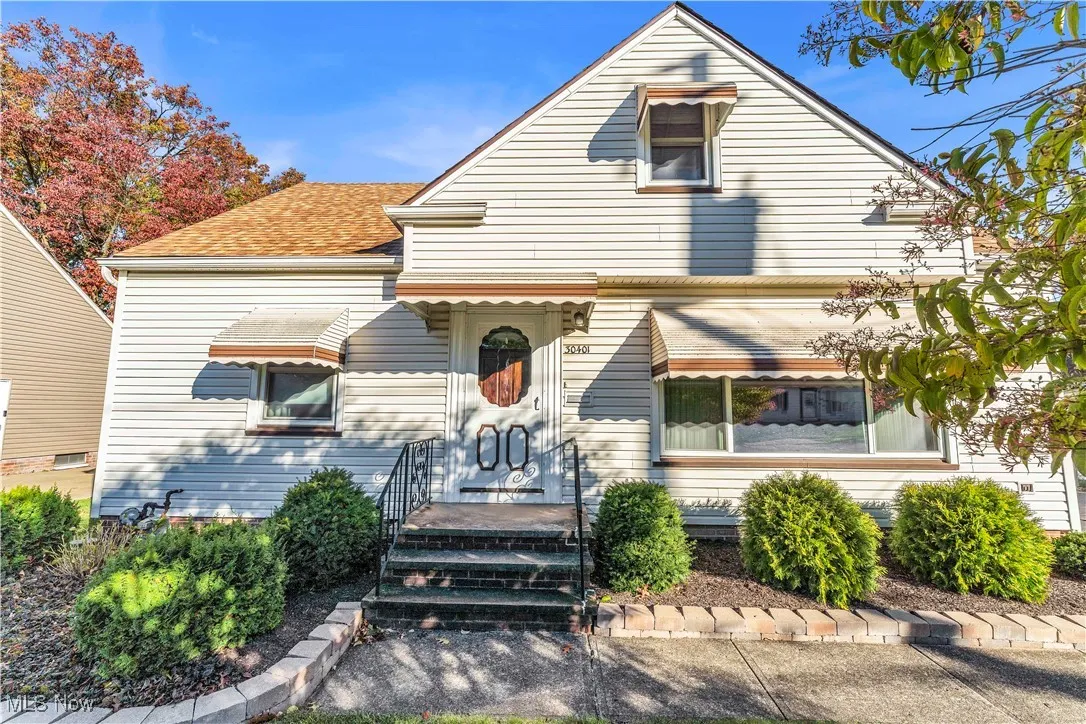 View of front of house with a shingled roof