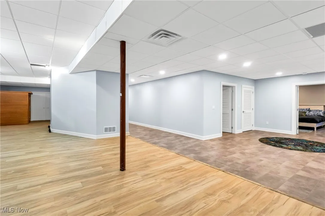 Finished basement featuring light wood-type flooring and a drop ceiling