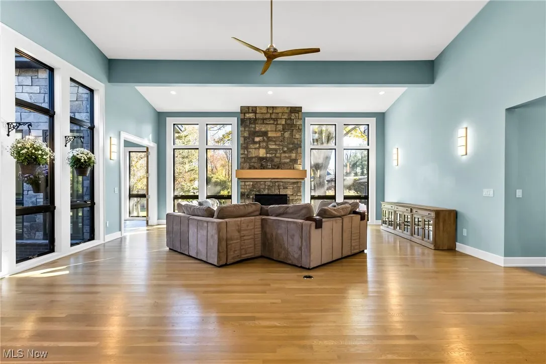 Living area featuring light wood-style floors, a fireplace, ceiling fan, and recessed lighting