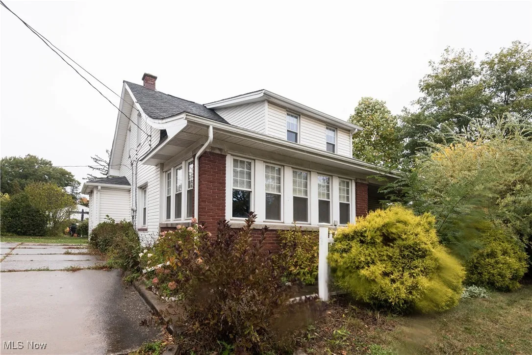 View of home's exterior featuring brick siding and a chimney