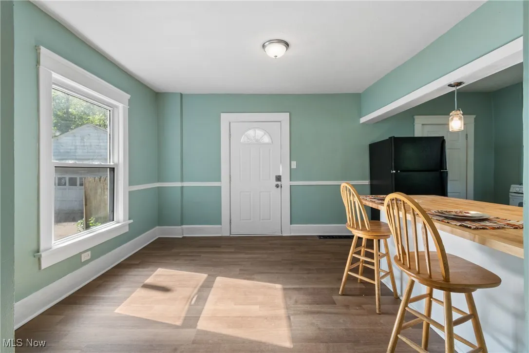 Dining space with dark wood-style floors and baseboards
