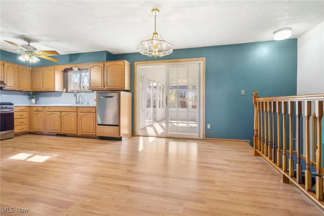 Dining room or eat in kitchen with light wood-type flooring, healthy amount of natural light and chandelier