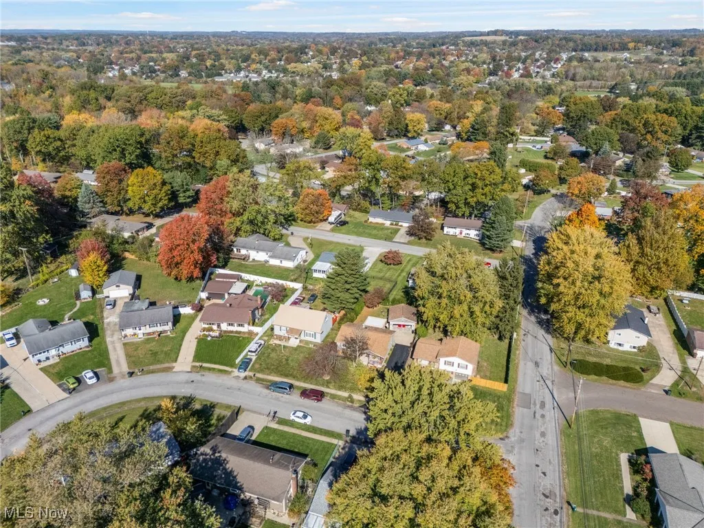 Aerial view of property and surrounding area featuring nearby suburban area
