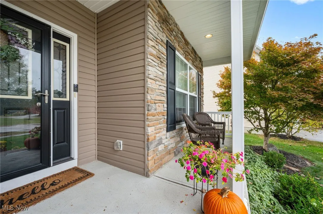 Property entrance featuring stone siding and a porch