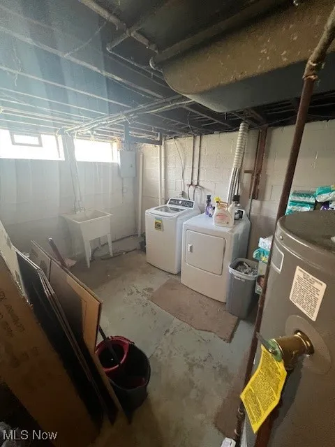 Basement with water heater and washer and clothes dryer