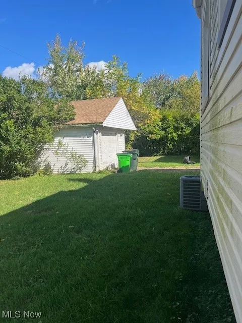 View of green lawn featuring an outbuilding