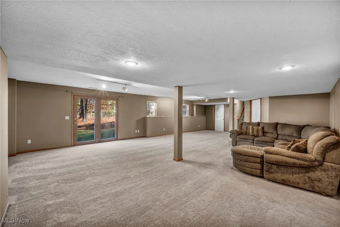 Living area featuring carpet and a textured ceiling