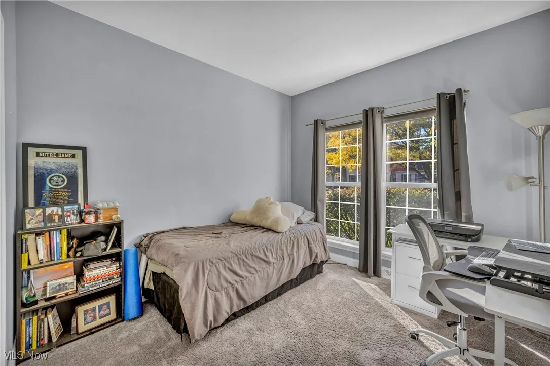 Bedroom with carpet floors and an office area