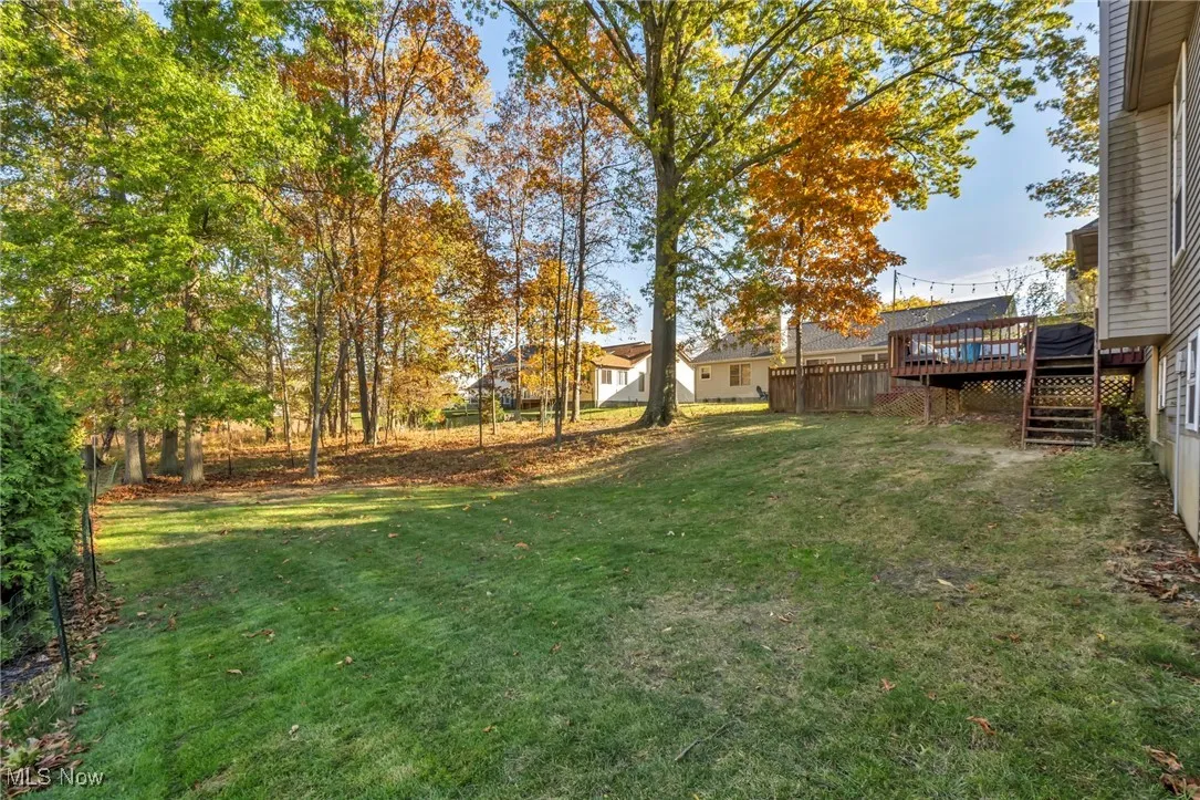 View of green lawn with a wooden deck