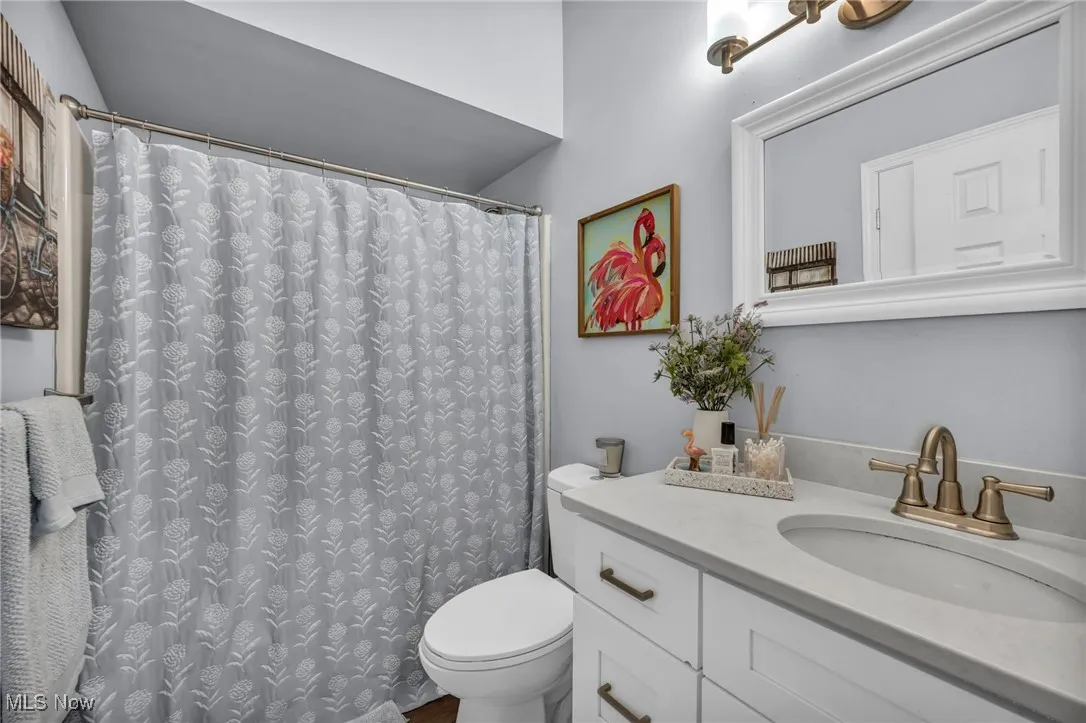 Bathroom with curtained shower and vanity