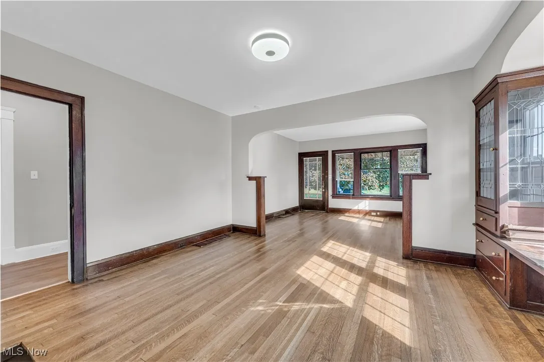 Unfurnished living room with light wood-style flooring and arched walkways