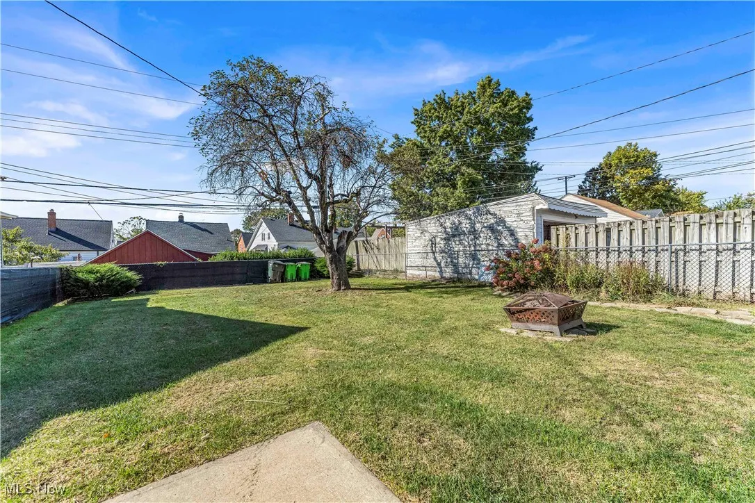 Fenced backyard with an outdoor fire pit