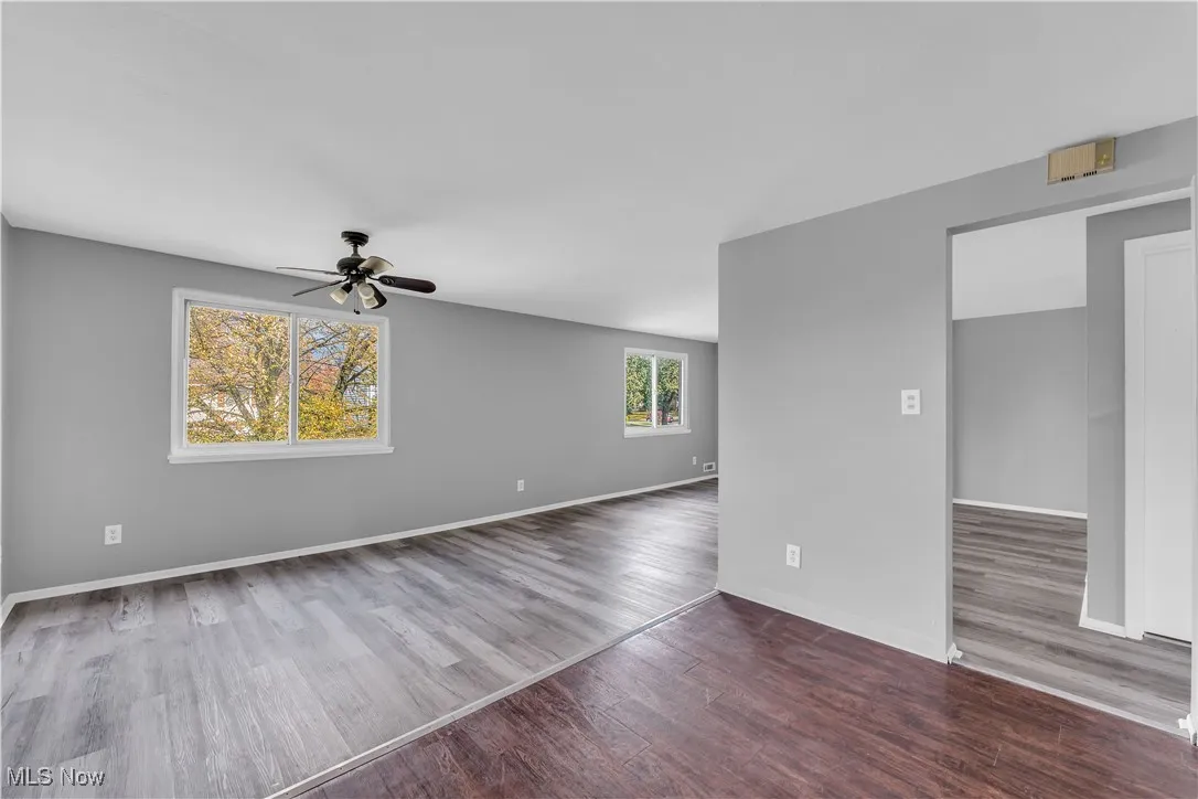 Empty room featuring dark wood-style floors and a ceiling fan