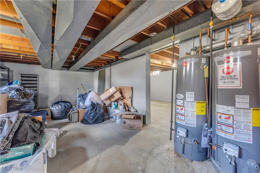 Unfinished below grade area featuring water heater