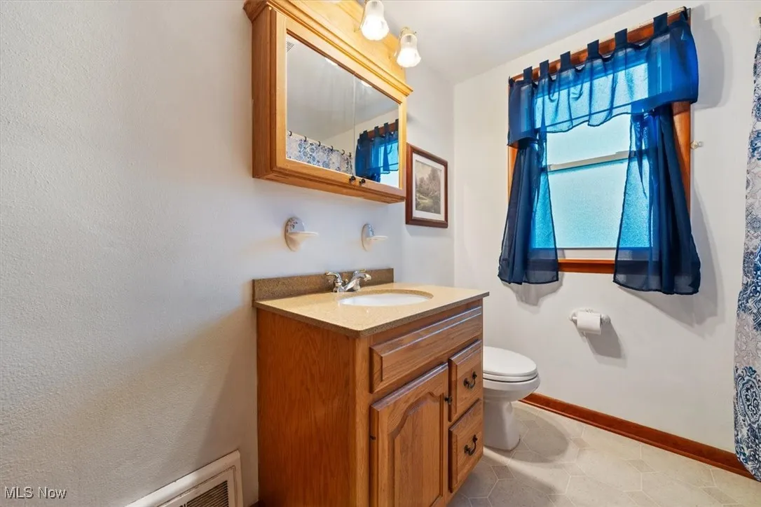 Bathroom with vanity, curtained shower, and light tile patterned floors