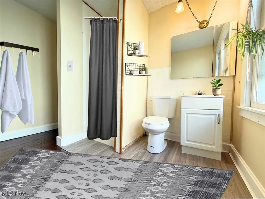 Bathroom with a stall shower, light wood-style floors, and vanity