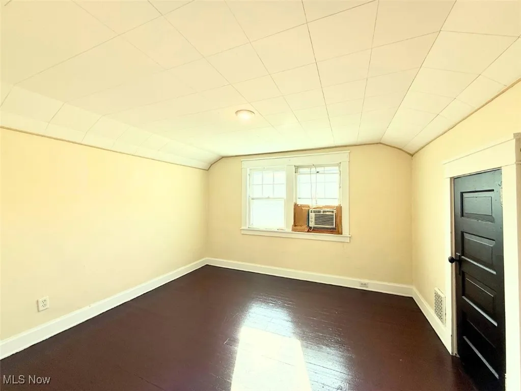 FH-MIDDLE BEDROOM space featuring lofted ceiling and dark wood-style floors