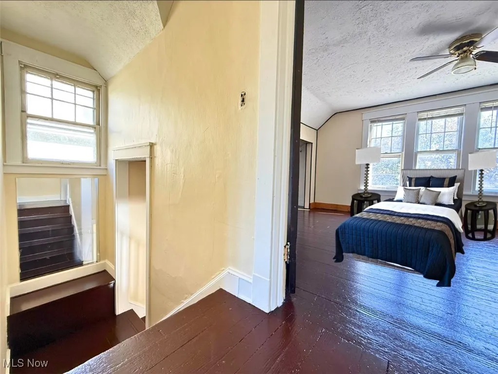 FH-STAIRWAY AND MST Bedroom with a textured ceiling, dark wood-style floors, and vaulted ceiling
