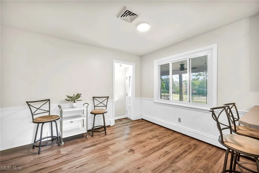 Sitting room with baseboard heating and light wood-style flooring