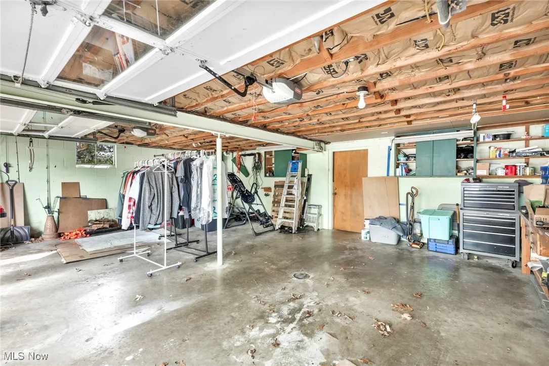 Garage featuring concrete block wall and a garage door opener