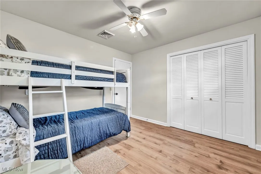 Bedroom featuring light wood-style flooring, ceiling fan, and a closet