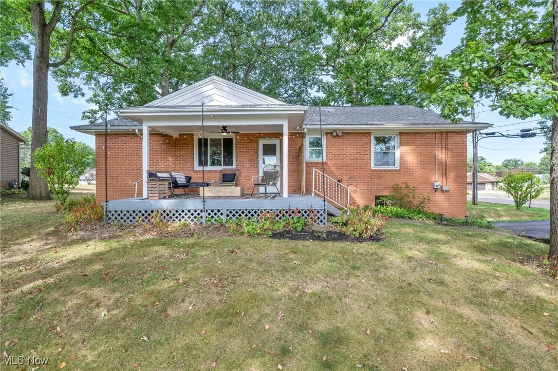 View of front of home featuring brick siding, a front lawn, and ceiling fan