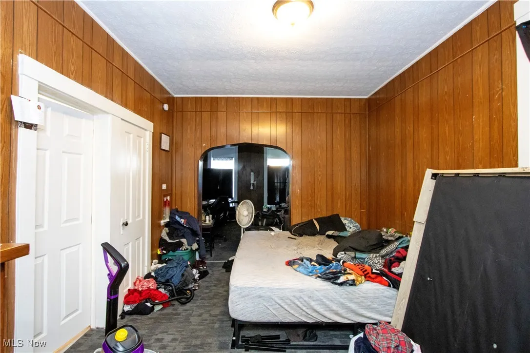 Carpeted bedroom with wood walls
