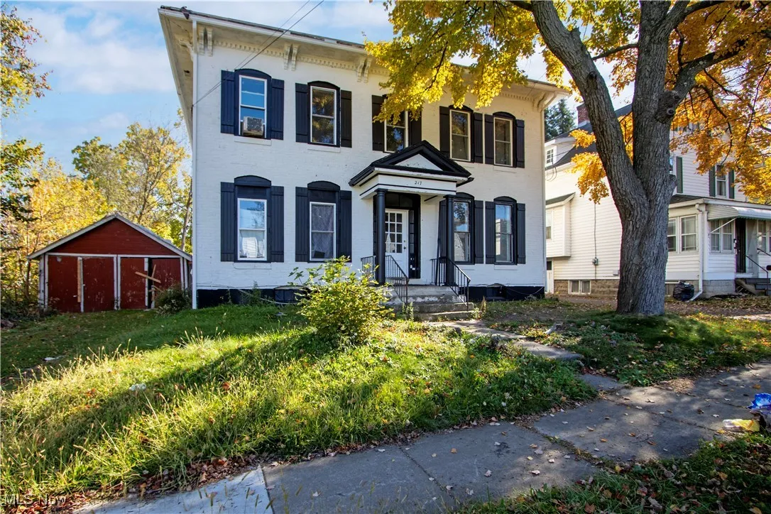 Italianate home with brick siding and an outdoor structure