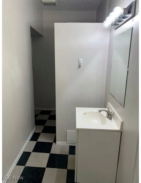 Half bath with dark flooring and vanity