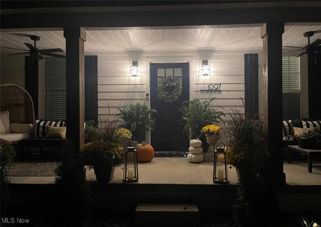 Entrance to property with ceiling fan and an outdoor living space