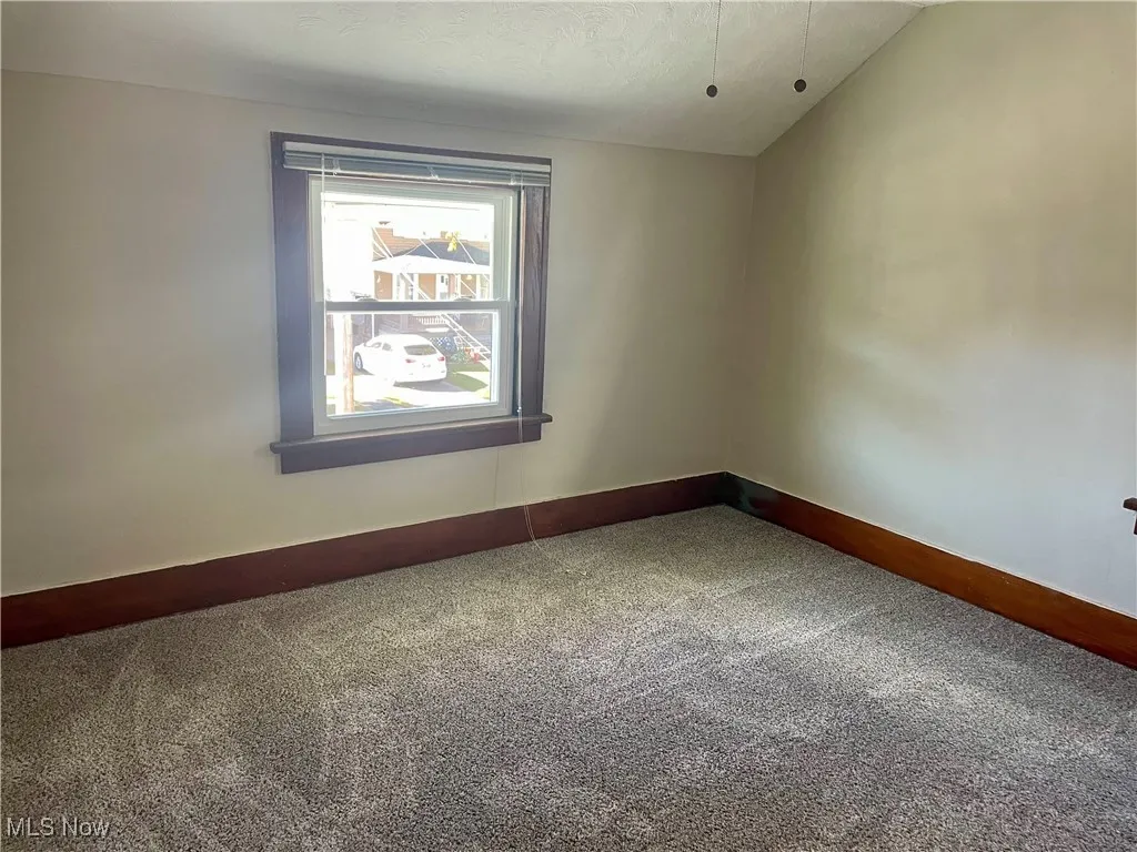 bedroom with carpet, vaulted ceiling, and a textured ceiling