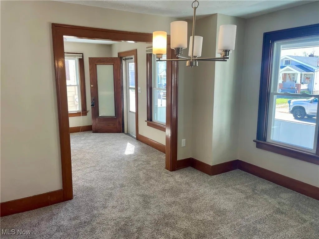 Unfurnished dining area with a chandelier and carpet floors