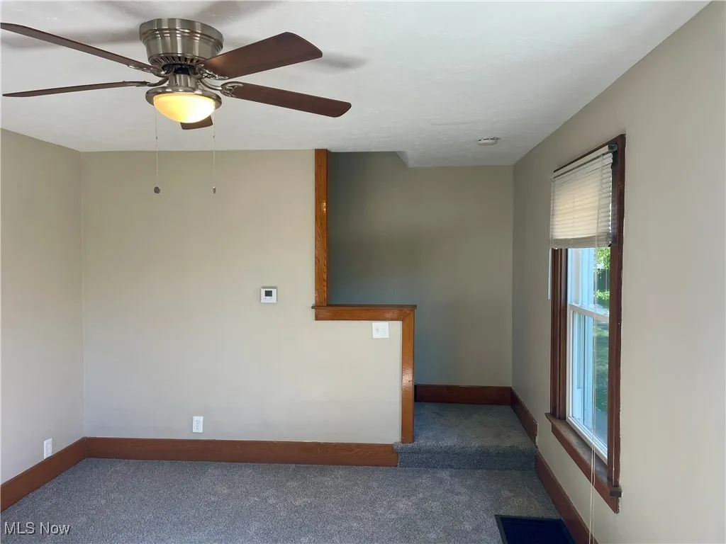 Empty room with carpet and ceiling fan