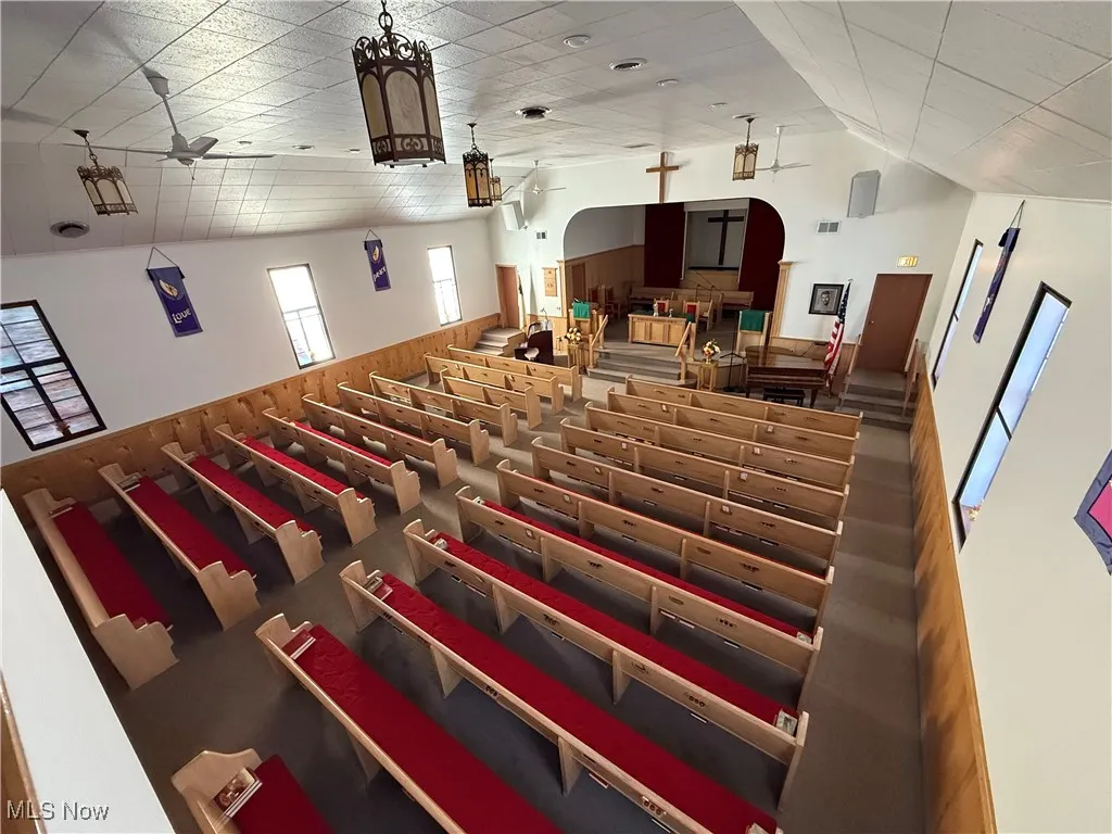 Cinema with wooden walls, a wainscoted wall, and ceiling fan
