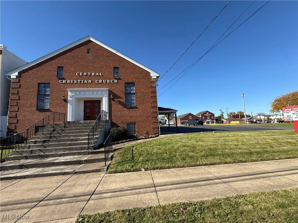 View of front of home with brick siding and a front lawn