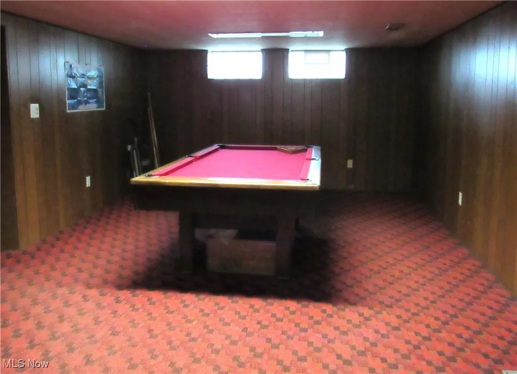 Rec room with wood walls, pool table, and carpet floors